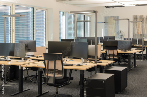 Modern IT office with rows of workstations.