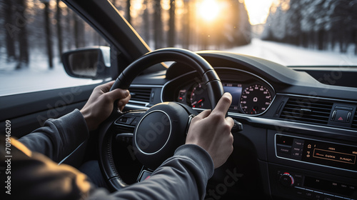 unrecognizable man driving car during a snowy day at sunset