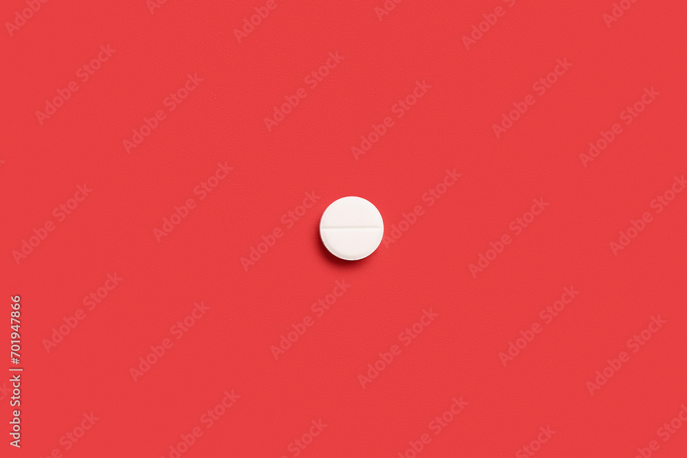 Medical pill on red background