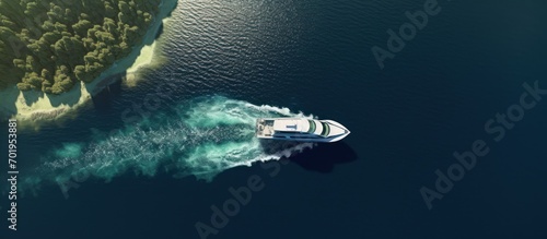 Beautiful aerial view of speedboat near a green cliff island photo