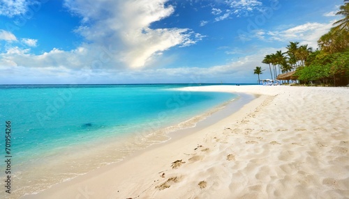 A scenic beauty unfolds: white sands, turquoise waves, and sunny blue skies.