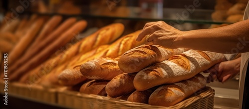 Woman buys a baguette from a customer freshly made in a bakery