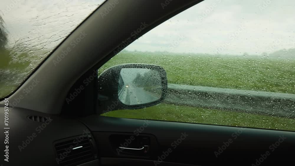 Wet weather drive: View from car wheel in heavy rain Wet weather drive: View from car wheel in heavy rain