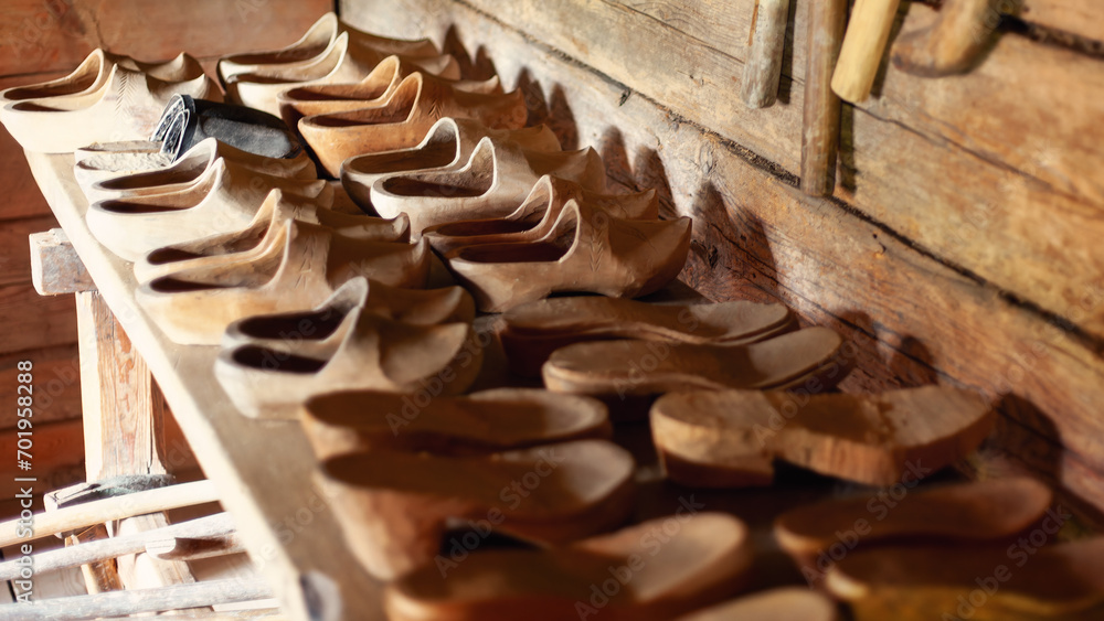 A collection of vintage wooden clogs on the wooden table