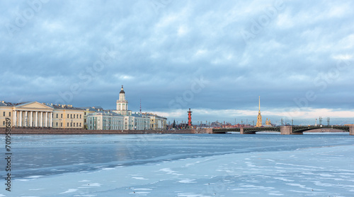View of the winter, icy Neva embankment with the building of the Kunstkammer Museum in winter St. Petersburg. Ice on the Neva River in St. Petersburg at sunset in winter. © Dmitry Presnyakov