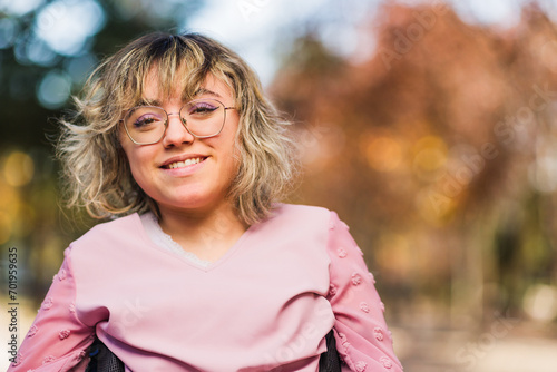 Young woman with cerebral palsy disability on wheelchair greeting and smile. Social inclusion