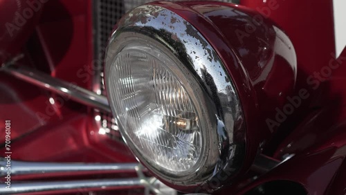 Old american car headlight with rust elements. Close up shiny light and front side of vintage auto. Front lights and bumper. Retro car