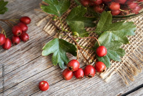 Fresh hawthorn berries and leaves on a wooden table