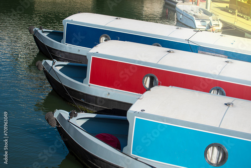 Recreational boats and houseboats are parked in the harbor on the river for private rental