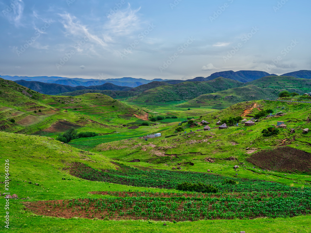 Traditional village in the Lesotho highlands surrounded by rolling hills and mountains