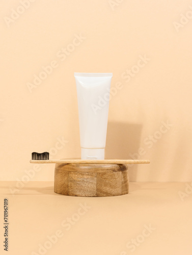White plastic toothpaste tube and wooden toothbrush