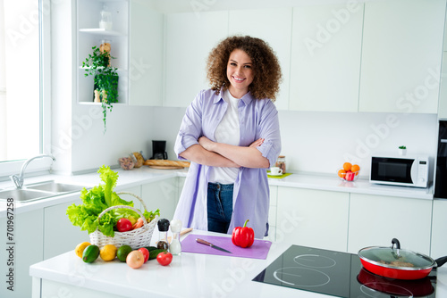 Photo of confident cute lady dressed purple shirt arms crossed cutting red sweet pepper preparing breakfast indoors house kitchen