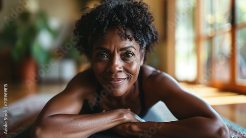 Professional Portrait of an active black African American mature woman smiling and doing fitness pilates at her home gym photo