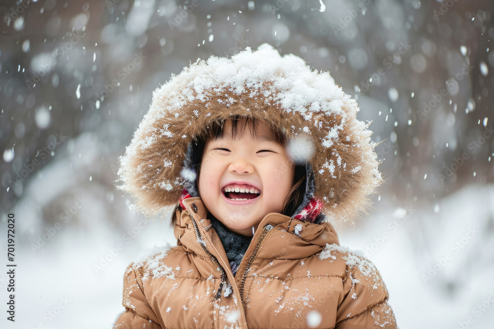 Happy kid wearing warm clothes plays outdoors with snow in winter. Happy kid wearing warm clothes plays outdoors with snow in winter.