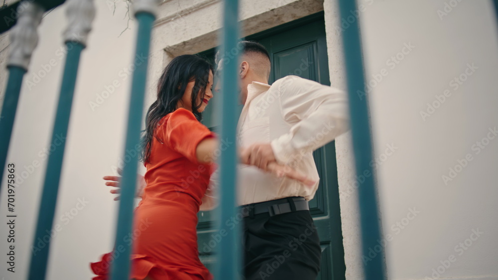 Couple dancers enjoy latino style choreography performing near street railings. Couple dancers enjoy latino style choreography performing near street railings.