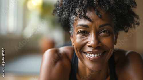 Professional Portrait of an active black African American mature woman smiling and doing fitness pilates at her home gym photo