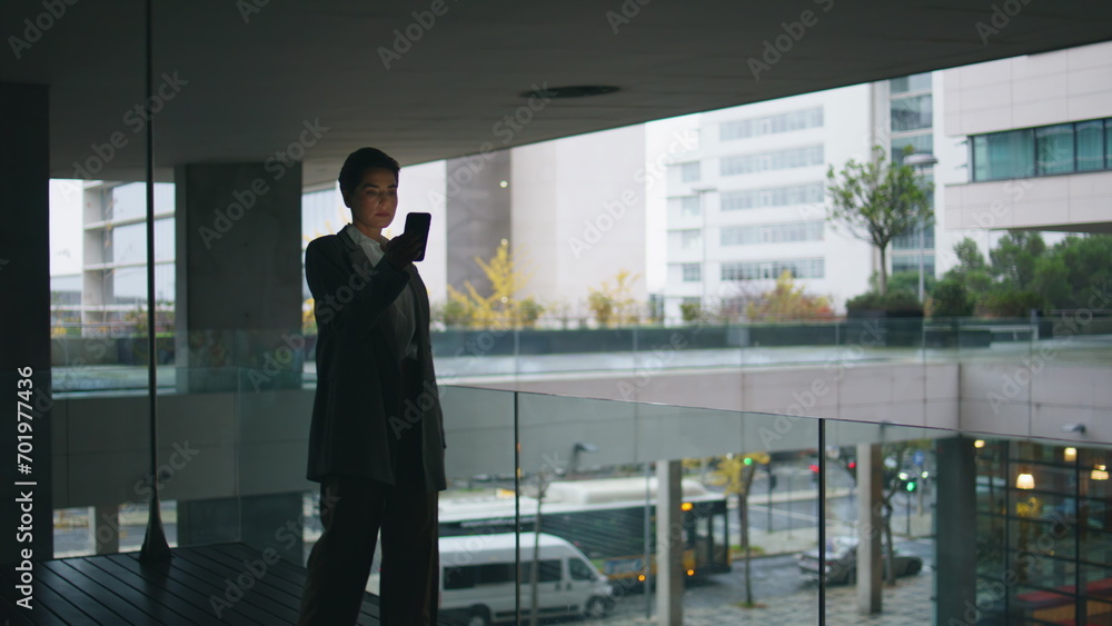 Thoughtful businesswoman looking smartphone on dark balcony. Nervous woman walk Thoughtful businesswoman looking smartphone on dark balcony. Nervous woman walk