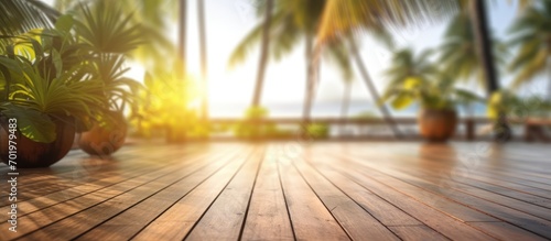 Wooden terrace Blur tropical beach with bokeh sunlight waves and palm trees in coffee photo room space
