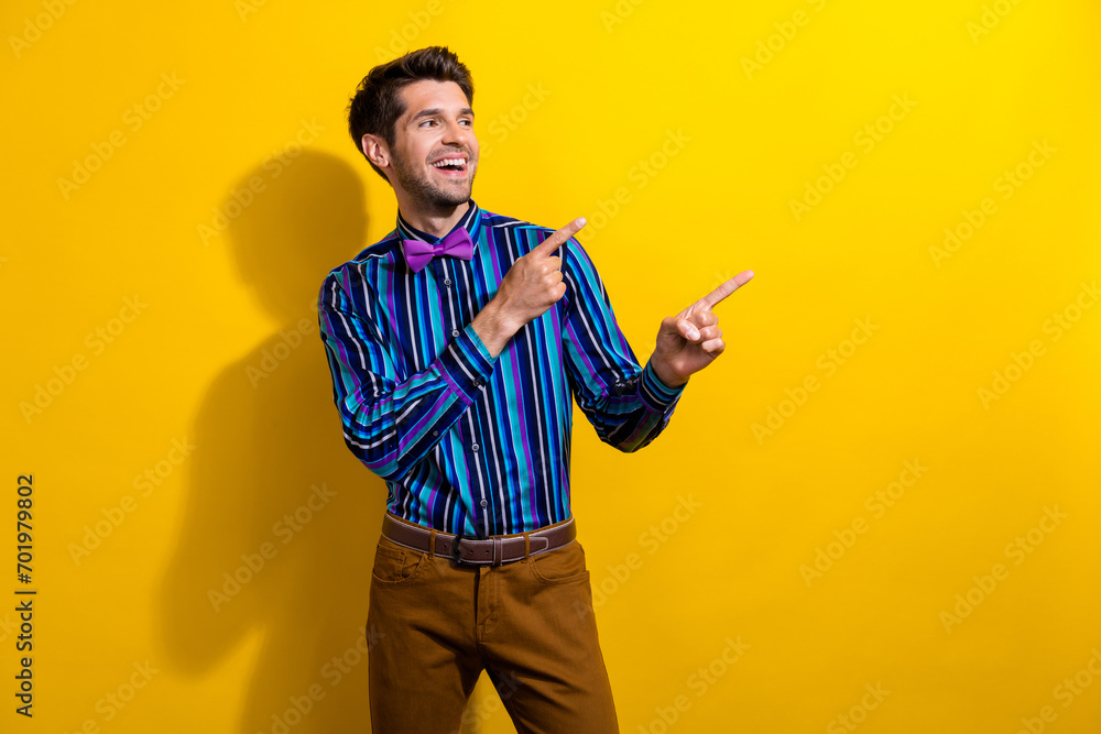 Portrait of cheerful guy dressed stylish shirt bow tie directing look at sale empty space isolated on bright yellow color background Portrait of cheerful guy dressed stylish shirt bow tie directing look at sale empty space isolated on bright yellow color background