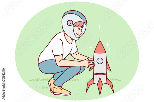 Little boy squatting near toy rocket representing launching spaceship to another planet. Child plays as astronaut, wanting to work in space industry and launch intergalactic ships. Flat vector design