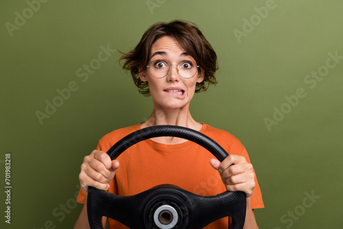 Photo of attractive funny woman in eyeglasses nervous first time examination test driving classes isolated on khaki color background