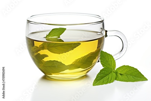 Black tea in a glass cup, isolated on a white background, alongside green tea leaf.