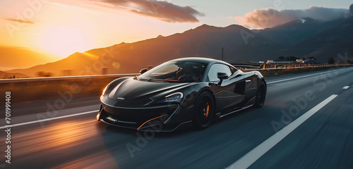 A sleek black supercar speeding down an open highway with mountains in the background  sun setting behind the peaks