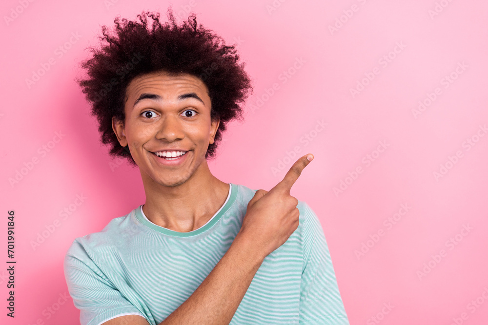 Photo of cheerful positive man dressed blue t-shirt pointing finger empty space isolated pink color background Photo of cheerful positive man dressed blue t-shirt pointing finger empty space isolated pink color background