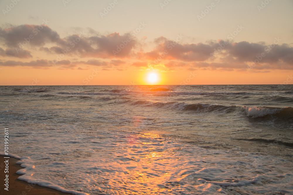 Sunrise from behind the sea, golden water and the edge of the coast in white waves. Sunrise from behind the sea, golden water and the edge of the coast in white waves.