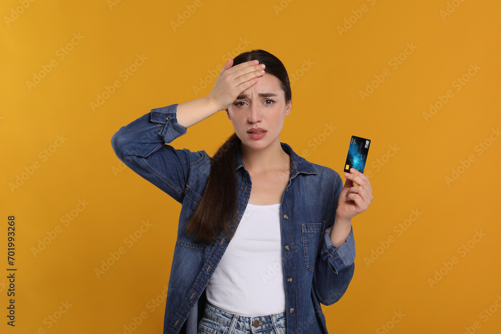 Worried woman with credit card on orange background. Debt problem Worried woman with credit card on orange background. Debt problem