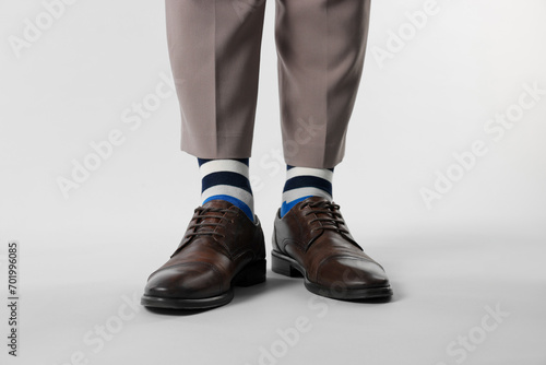 Man in stylish colorful socks, shoes and pants on white background, closeup