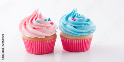 Cupcakes with blue and pink decoration on white background, close up view. Gender reveal party