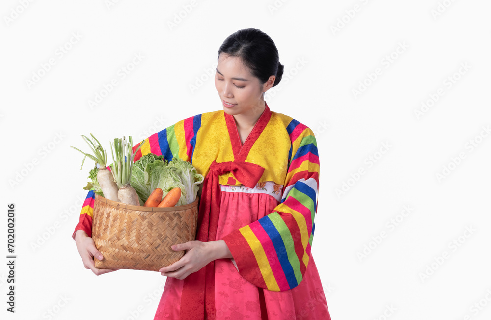 Beautiful Korean girl wearing traditional hanbok Carrying a lot of fresh vegetables in a basket On white background for health care and clean food concept. Beautiful Korean girl wearing traditional hanbok Carrying a lot of fresh vegetables in a basket On white background for health care and clean food concept.