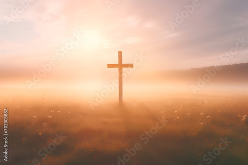 Symbolizing Ascension Day: A cross stands tall against an autumn sunrise meadow backdrop. © Uliana