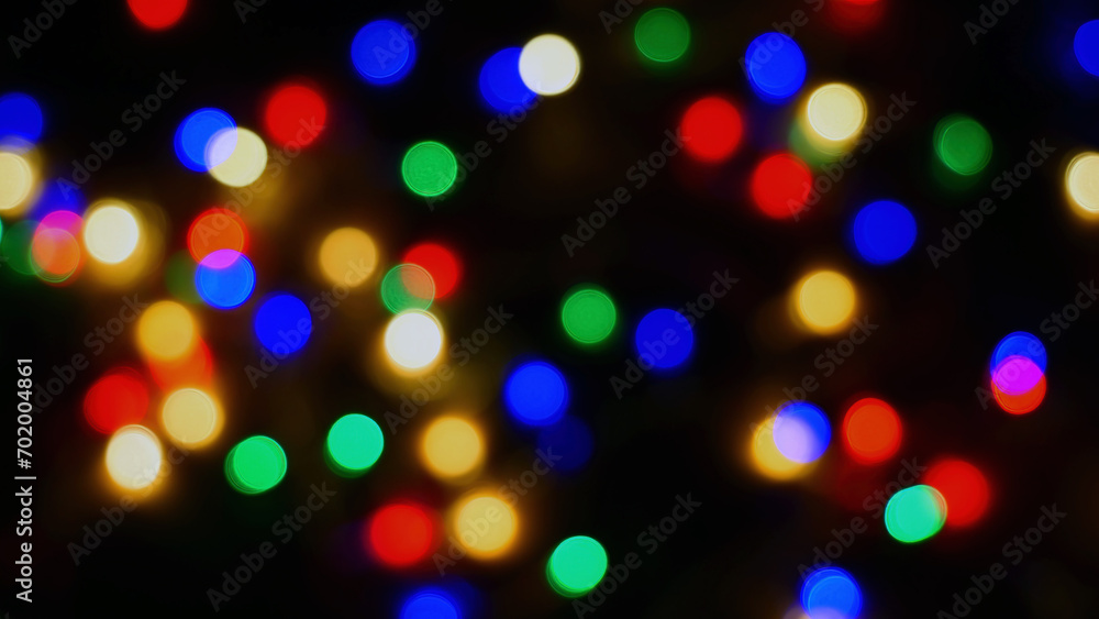 Defocused blurry multicolored blinker lights bokeh of Christmas and New year decoration lights, abstract, dark background, overlay for party, shallow DOF, festive mood