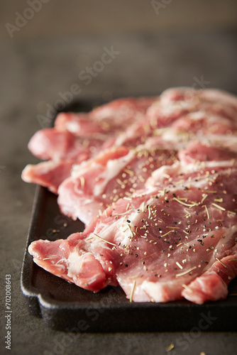 Raw neck meat seasoned with spices on a plate 