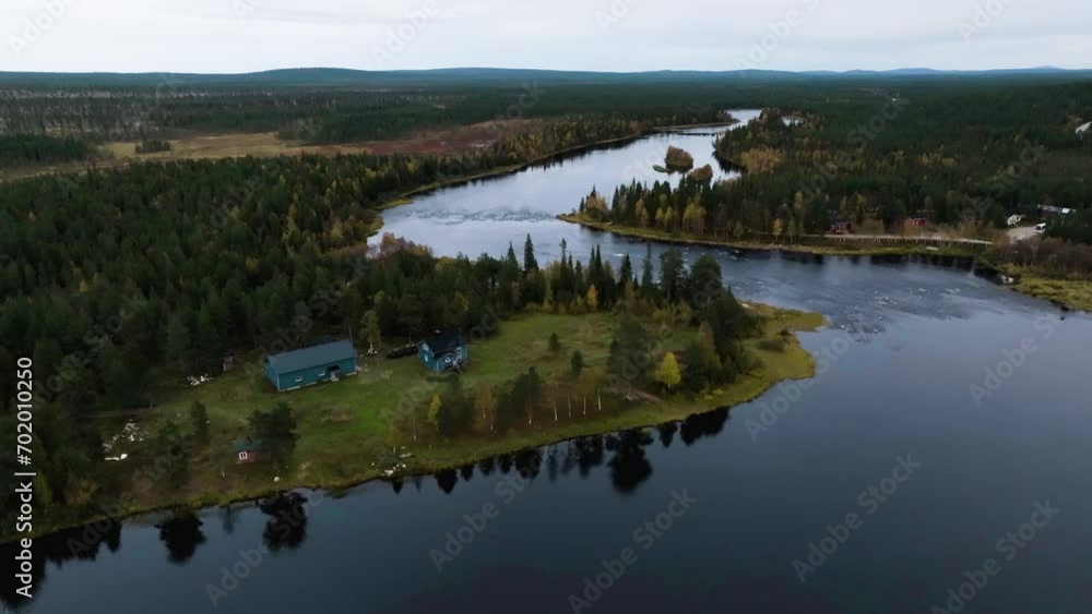 Drone shot passing a rural house, following river rapids, dark, fall day in Lapland Drone shot passing a rural house, following river rapids, dark, fall day in Lapland