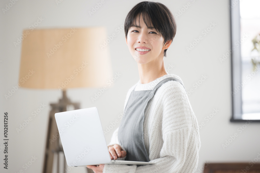 部屋でパソコンを使い、売上などを考えるのショップの販売員や接客業のような女性のクローズアップ 部屋でパソコンを使い、売上などを考えるのショップの販売員や接客業のような女性のクローズアップ