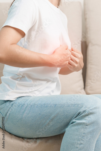woman having abdomen ache due to Stomach pain, digestion with constipation or Diarrhea from food poisoning and liver cancer on the sofa at home