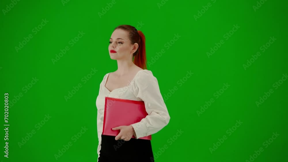 Portrait of attractive office girl on chroma key green screen. Woman in skirt and blouse walking with paper folder and red gift paper bags. Half turn. Portrait of attractive office girl on chroma key green screen. Woman in skirt and blouse walking with paper folder and red gift paper bags. Half turn.