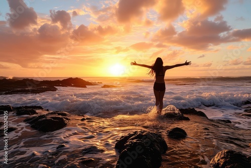 A successful professional finds solace and celebration at the beach, her arms open towards the sunrise as she embraces the opportunities and challenges of a new day. photo