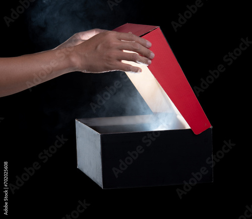 hand hold and open a mysterious box, smoke float up from box over dark background
