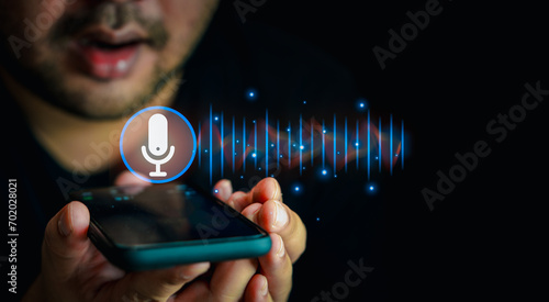 Close up of man holding in hand smart phone talking with digital assistant or friend distantly uses easy voice messaging, concept of modern ai technology use voice to direct photo