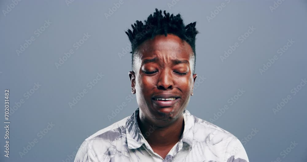 Sad, crying and face of black man in a studio with upset, worry and depression expression. Emotions, grief and portrait of young African male person with tears or broken heart on gray background.