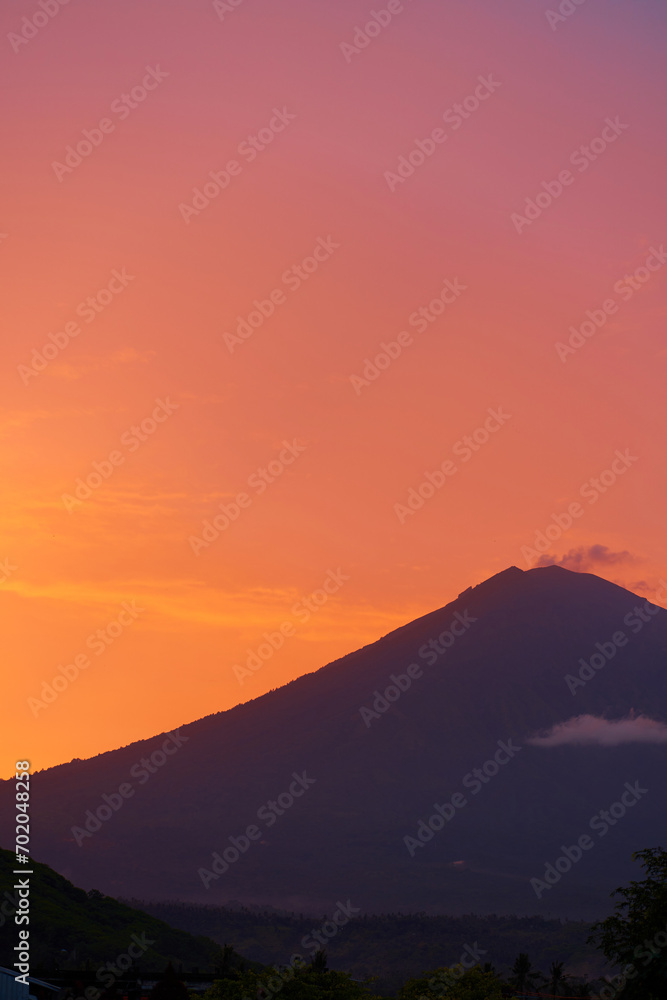 Silhouette of the Agung volcano at sunset. Panorama of the mountain on the island of Bali.
