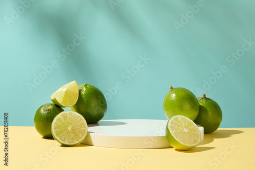 Fresh lemons are placed next to a white podium on a pastel background. The acid in lemon has antibacterial and astringent effects that help remove blackheads on the face gently and effectively. photo