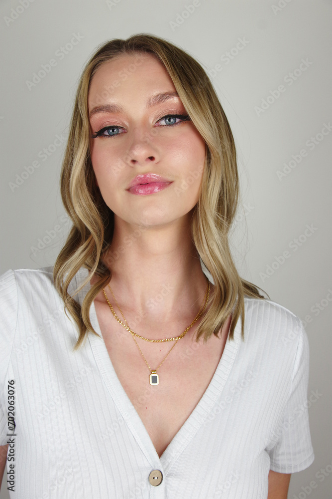 Stunning Blue-Eyed Brunette in a White Shirt Showcasing an Elegant Gold Necklace on a Pure White Canvas Stunning Blue-Eyed Brunette in a White Shirt Showcasing an Elegant Gold Necklace on a Pure White Canvas
