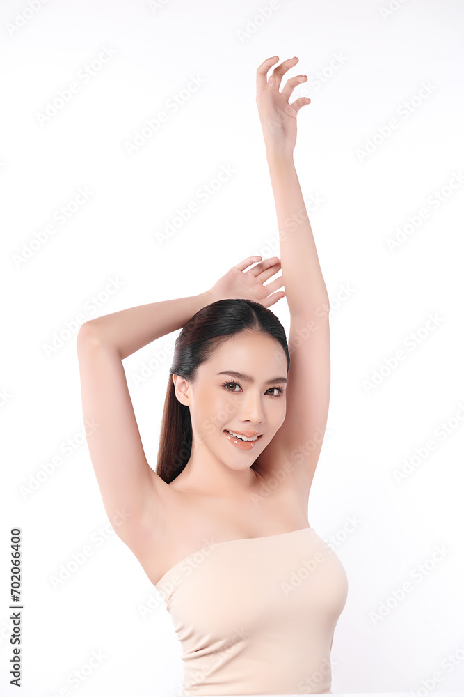 Obraz premium Beautiful Young Asian woman lifting hands up to show off clean and hygienic armpits or underarms on white background, Smooth armpit cleanliness and protection concept