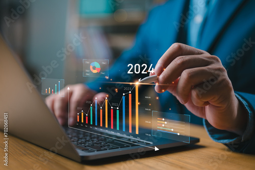Businessman investor analyzes profitability of working companies with digital augmented reality graphics, positive indicators in 2024, businessman calculates financial data for long-term investments. photo