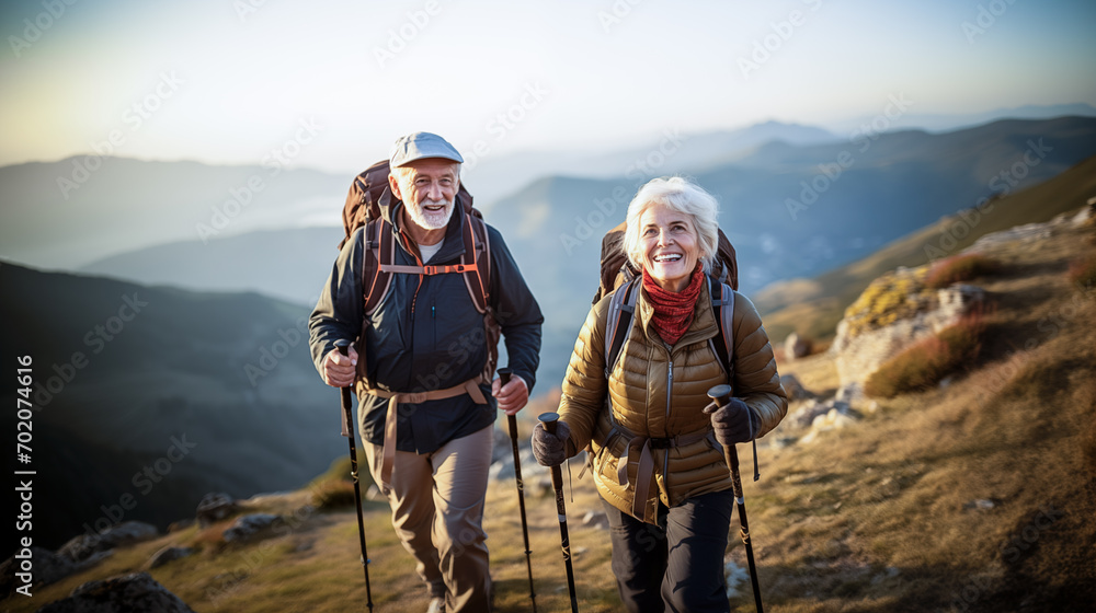 A photo of an elderly couple on a hike up the mountain. - obrazy, fototapety, plakaty 